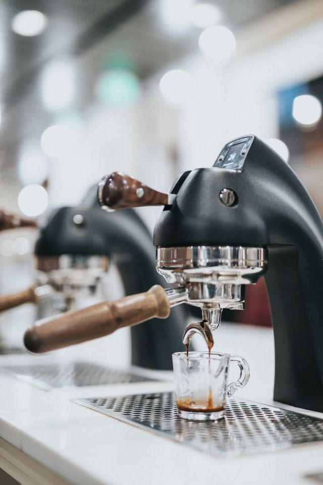 counter with 2 professional espresso machines and an empty glass